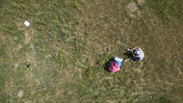 7月29日，在呼伦贝尔农垦集团谢尔塔拉农场的天然草地恢复技术示范区，两名科研人员正在用植物光合作用测定仪测量人工草场里物种的生长情况。新华社记者 金立旺 摄
