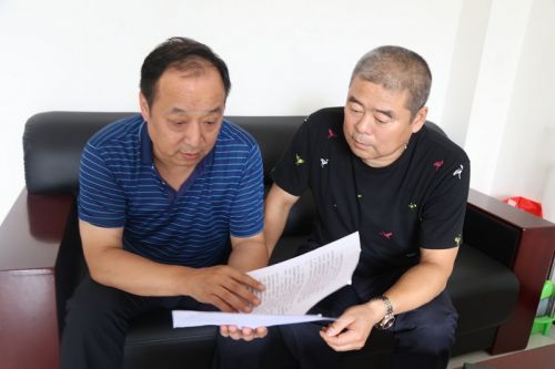 图8：万运巫山分公司经理罗俊杰（左）副经理何勇（右）细化脱贫攻坚村村通工作