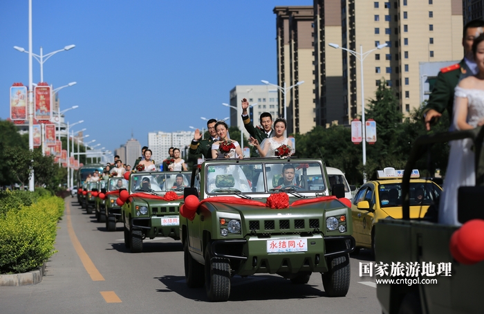 12——图为参加集体婚礼的车队行驶在市区公路上。