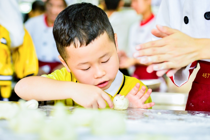 6、2020年11月18日，在广西梧州商贸学校，幼儿园的小朋友与老师一起亲子面点制作体验，从小培养热爱劳动的良好习惯。