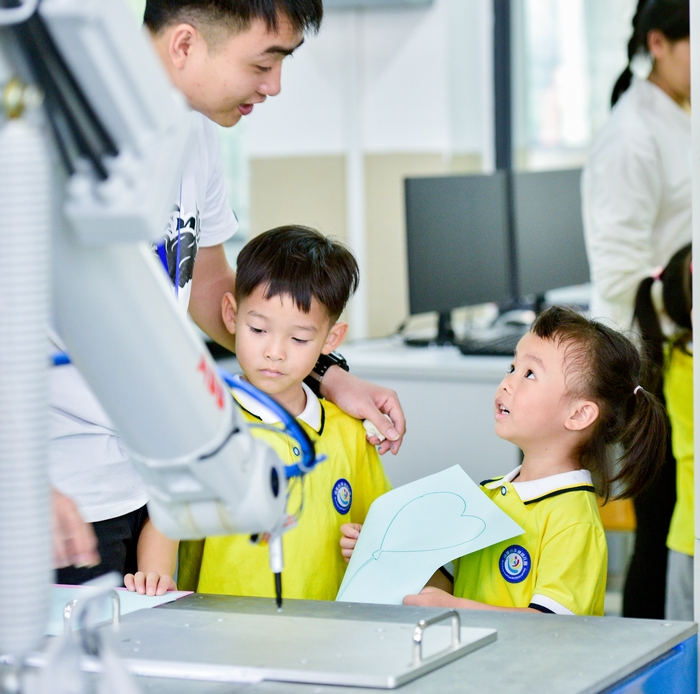 13、2020年11月18日，在广西梧州商贸学校幼儿园的小朋友饶有兴趣参观工业智能制造体验，感受科技的魅力。