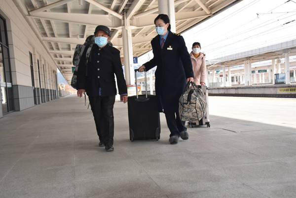 1月28日，在婺源高铁站，工作人员帮助旅游搬运行李。