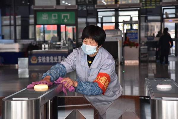 1月28日，在婺源高铁站，工作人员消毒保洁验票设施。