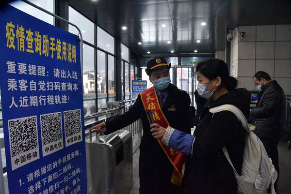 1月28日，在婺源高铁站，工作人员指引旅客扫码查询行程轨迹、健康状况。