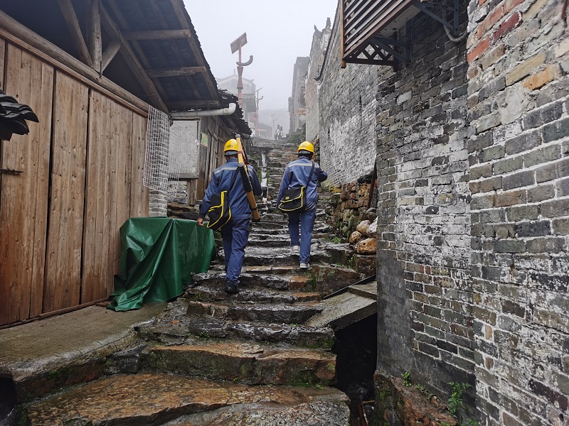 三排供电所员工唐考传吊、房帮计一在瑶寨开展用电巡查检查。