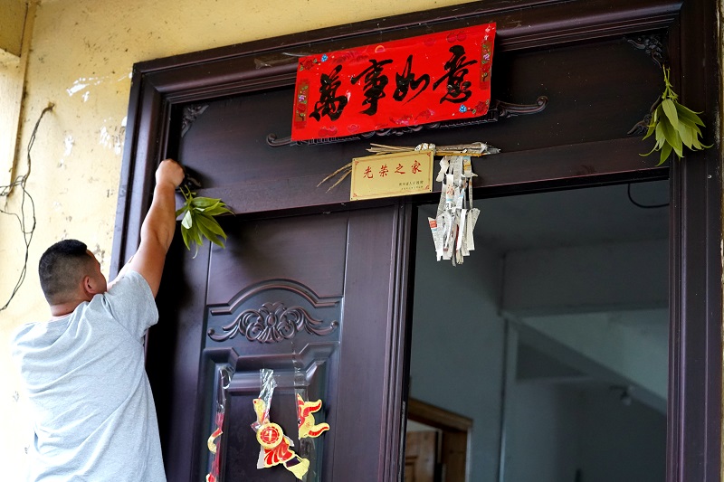 图12.4月18日，贵州从江县拱孖村村民将“乌米饭”树叶插在自家大门上。（1）