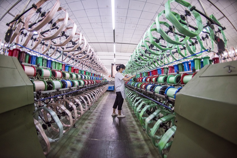 3、2021年8月16日，在广西蒙山县丝绸产业园区五丰丝绸有限公司丝绸车间内，工人们正在赶制真丝绸产品订单。