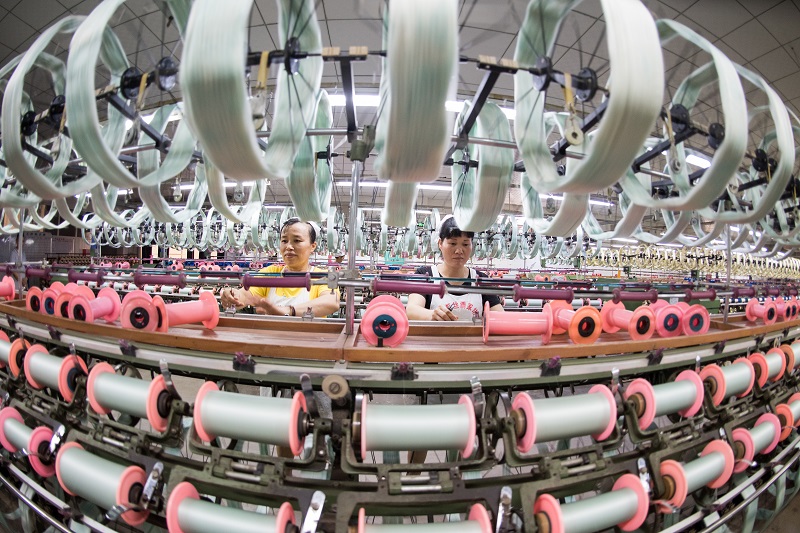 6、2021年8月16日，在广西蒙山县丝绸产业园区广西华虹蚕丝股份有限公司丝绸车间内，工人们正在赶制真丝绸产品订单。