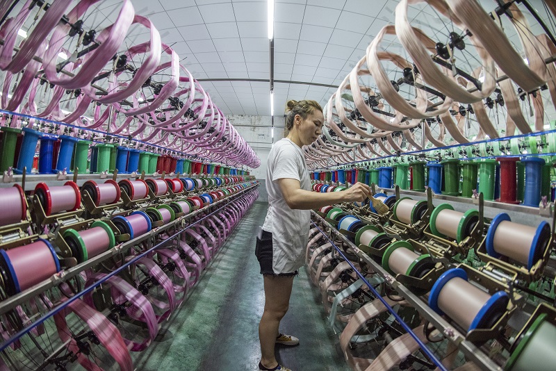 12、2021年8月16日，在广西蒙山县丝绸产业园区五丰丝绸有限公司丝绸车间内，工人们正在赶制真丝绸产品订单。