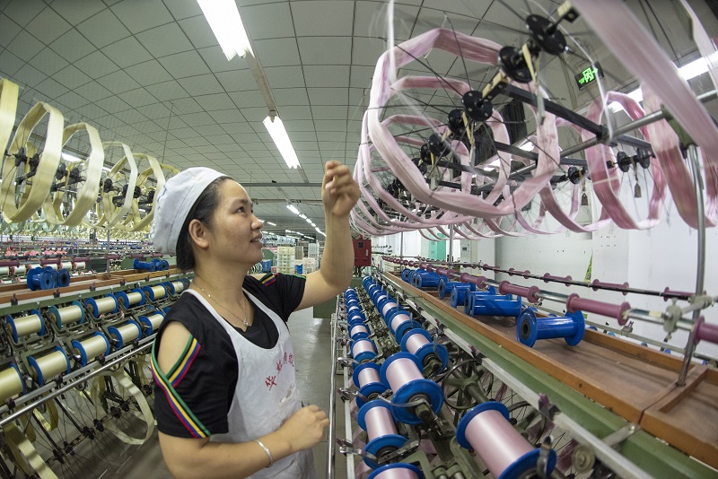 14、2021年8月16日，在广西蒙山县丝绸产业园区广西华虹蚕丝股份有限公司丝绸车间内，工人们正在赶制真丝绸产品订单。