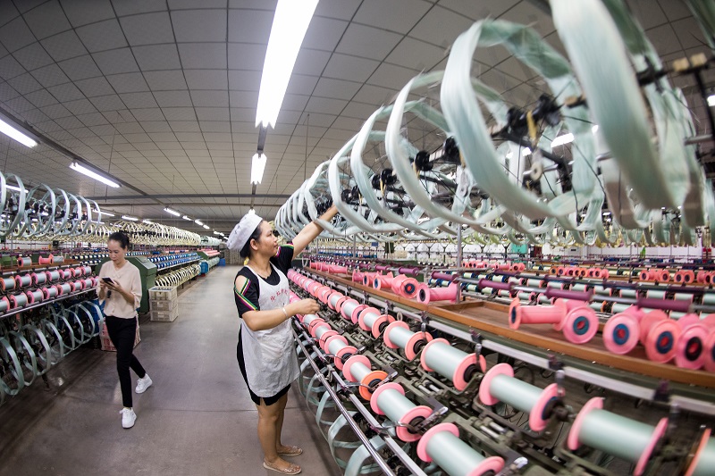 15、2021年8月16日，在广西蒙山县丝绸产业园区广西华虹蚕丝股份有限公司丝绸车间内，工人们正在赶制真丝绸产品订单。