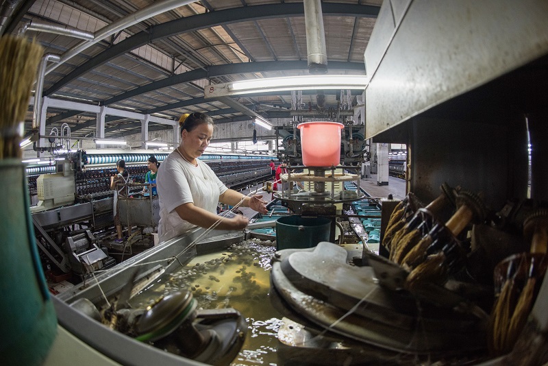 18、2021年8月16日，在广西蒙山县丝绸产业园区广西华虹蚕丝股份有限公司丝绸车间内，工人们正在赶制真丝绸产品订单。