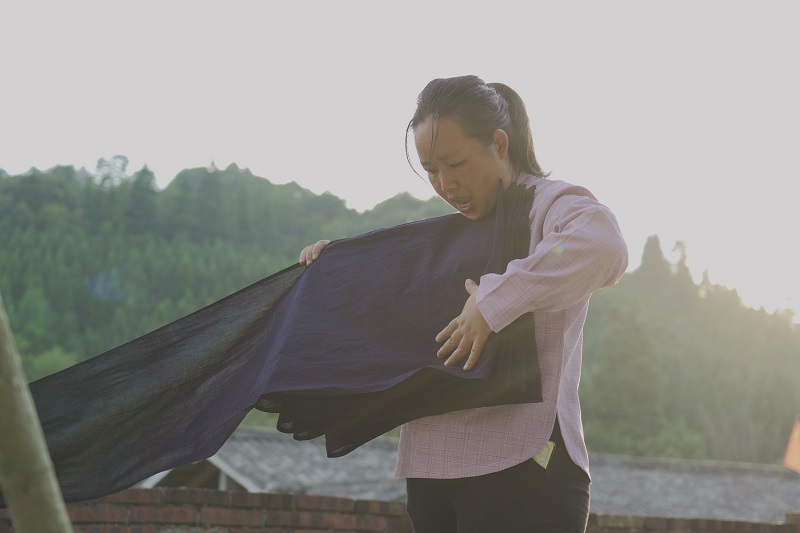 2021年8月25日，在从江县西山镇拱孖村，村民正在收下已晒干的侗布。