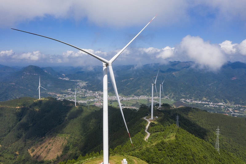 1、2021年9月25日，在广西梧州岑溪市大隆镇东南一带山脊上的中广核风电场现场，青山叠翠，15台风力发电机组与云雾、乡村相映成景，构成了一道美丽的绿色画卷。（何华文）