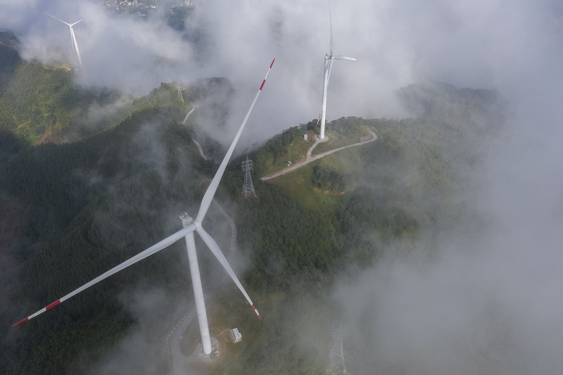 6、2021年9月25日，在广西梧州岑溪市大隆镇东南一带山脊上的中广核风电场现场，青山叠翠，15台风力发电机组与云雾、乡村相映成景，构成了一道美丽的绿色画卷。（何华文）