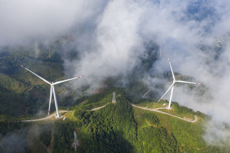 7、2021年9月25日，在广西梧州岑溪市大隆镇东南一带山脊上的中广核风电场现场，青山叠翠，15台风力发电机组与云雾、乡村相映成景，构成了一道美丽的绿色画卷。（何华文）