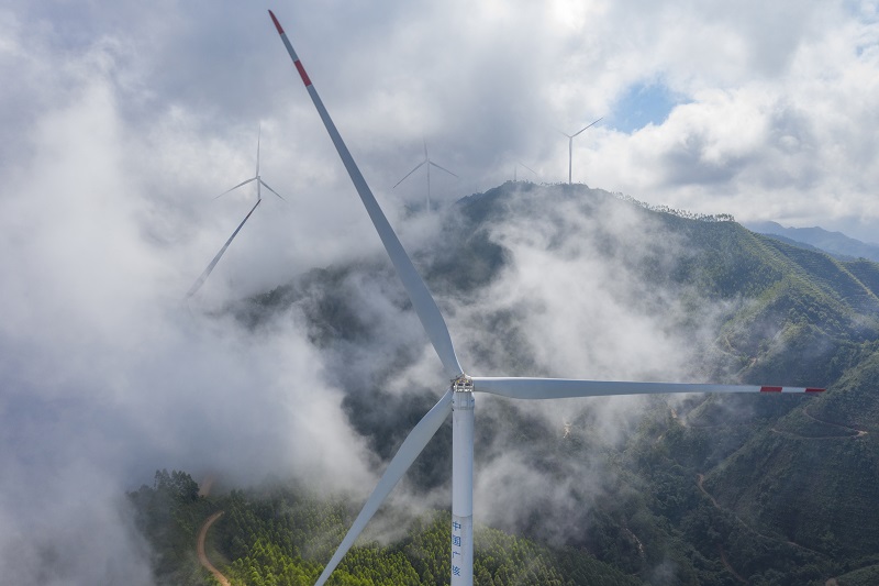 9、2021年9月25日，在广西梧州岑溪市大隆镇东南一带山脊上的中广核风电场现场，青山叠翠，15台风力发电机组与云雾、乡村相映成景，构成了一道美丽的绿色画卷。（何华文）