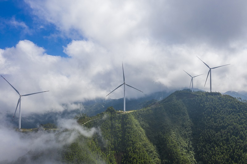 11、2021年9月25日，在广西梧州岑溪市大隆镇东南一带山脊上的中广核风电场现场，青山叠翠，15台风力发电机组与云雾、乡村相映成景，构成了一道美丽的绿色画卷。（何华文）