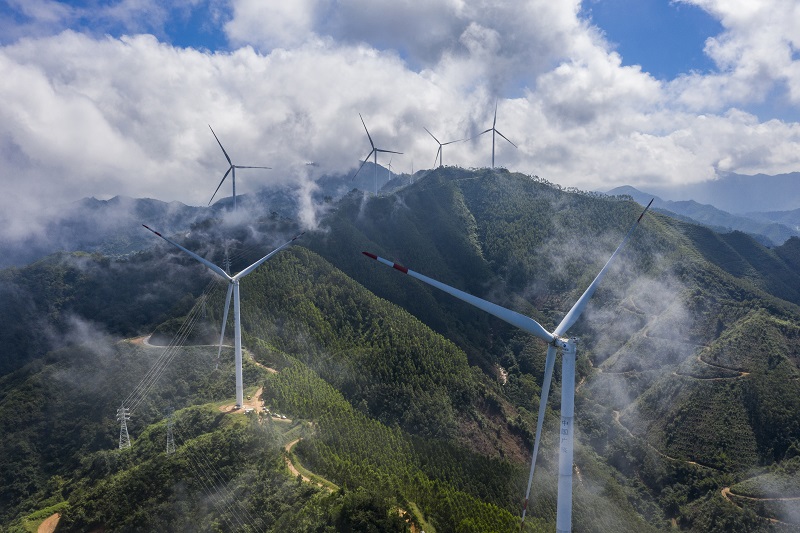 13、2021年9月25日，在广西梧州岑溪市大隆镇东南一带山脊上的中广核风电场现场，青山叠翠，15台风力发电机组与云雾、乡村相映成景，构成了一道美丽的绿色画卷。（何华文）