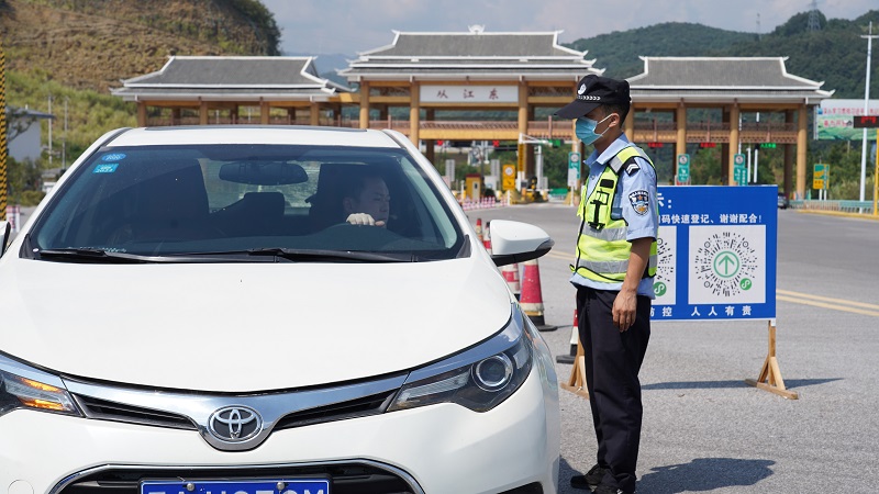 2021年10月1日，在夏蓉高速从江东站，交警队员正在疏导车辆人员下车登记、量体温并扫描健康码。 (3)