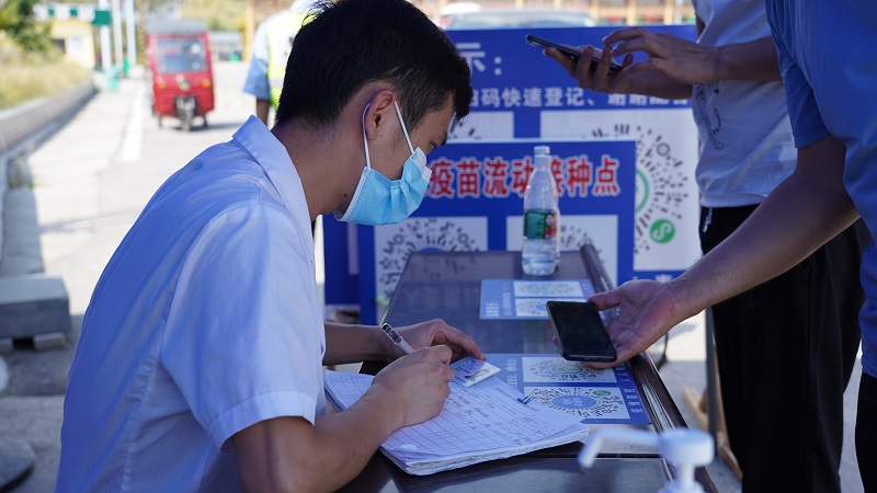 2021年10月1日，在夏蓉高速从江东站，医务工作者正在查看入境人员身份证。