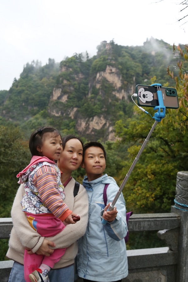12——10月4日，游客在甘肃省平凉市崆峒山上欣赏、拍摄雨景。