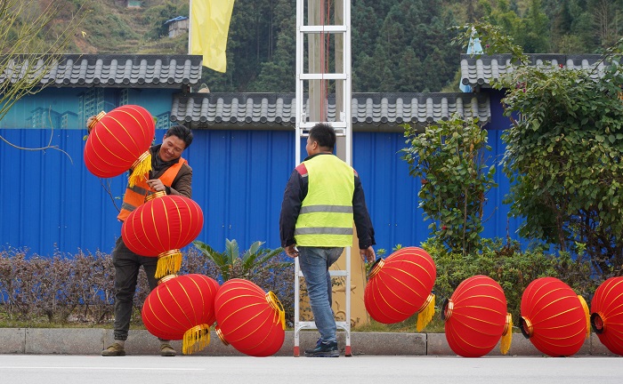 2022年1月24日，在从江县城街道两旁，工人正赶着挂灯笼。 (1)