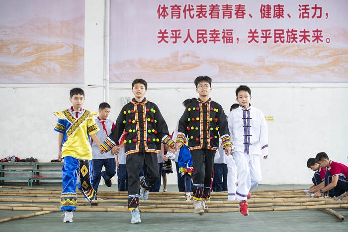 2、2022年5月13日，广西梧州市第十四中学师生在校园里一起共跳竹竿舞。（何华文）