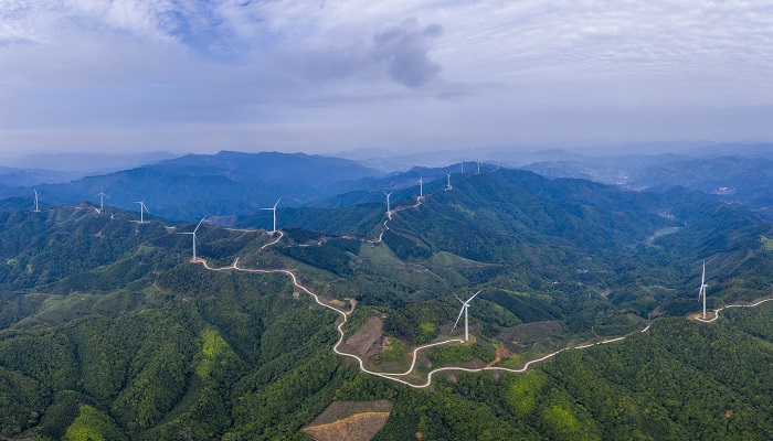 1、2022年5月19日，广西梧州市苍梧县六堡镇润堡风电场，一座座风力发电机组矗立山脊之上迎风旋转，与绿色群山、民居、村道相映成趣，美如画卷。（何华文）