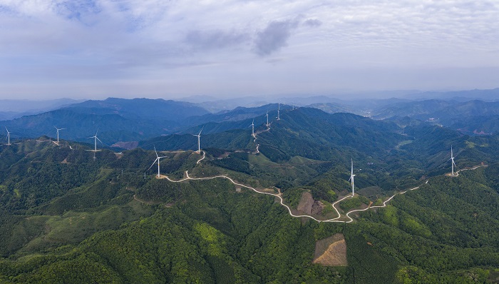 2、2022年5月19日，广西梧州市苍梧县六堡镇润堡风电场，一座座风力发电机组矗立山脊之上迎风旋转，与绿色群山、民居、村道相映成趣，美如画卷。（何华文）