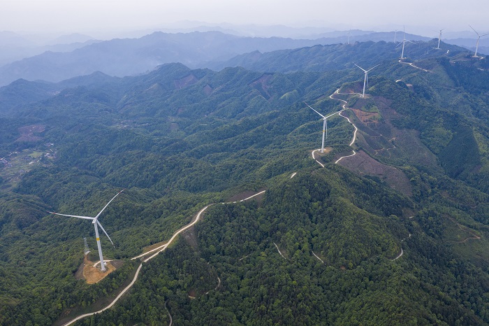 3、2022年5月19日，广西梧州市苍梧县六堡镇润堡风电场，一座座风力发电机组矗立山脊之上迎风旋转，与绿色群山、民居、村道相映成趣，美如画卷。（何华文）