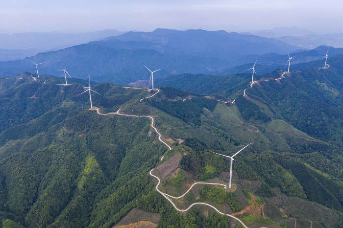 5、2022年5月19日，广西梧州市苍梧县六堡镇润堡风电场，一座座风力发电机组矗立山脊之上迎风旋转，与绿色群山、民居、村道相映成趣，美如画卷。（何华文）