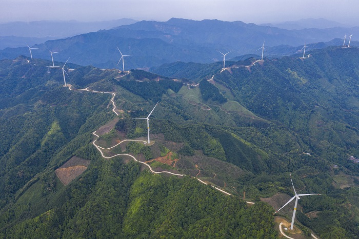 13、2022年5月19日，广西梧州市苍梧县六堡镇润堡风电场，一座座风力发电机组矗立山脊之上迎风旋转，与绿色群山、民居、村道相映成趣，美如画卷。（何华文）