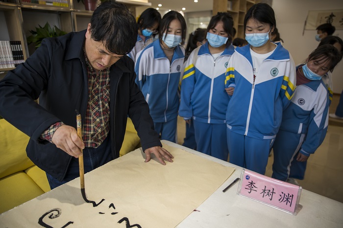 2022年5月12日，在贵州省六枝特区第七中学的图书馆，书画家们在现场书写作画，与同学们交流创作心得。 (3)