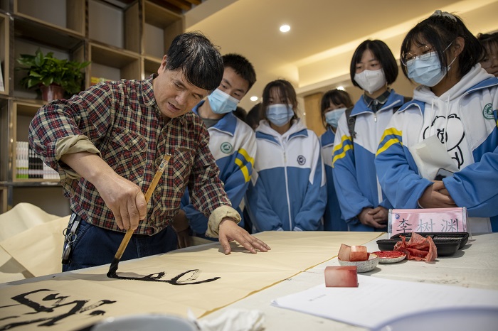 2022年5月12日，在贵州省六枝特区第七中学的图书馆，书画家们在现场书写作画，与同学们交流创作心得。 (5)