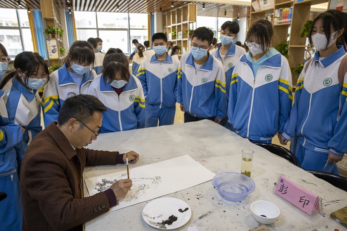 2022年5月12日，在贵州省六枝特区第七中学的图书馆，书画家们在现场书写作画，与同学们交流创作心得。 (6)