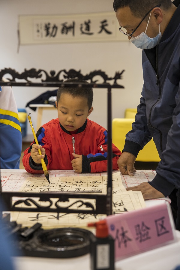 2022年5月12日，在贵州省六枝特区第七中学的图书馆，小朋友在体验区现场书写。