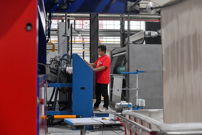 4、2022年5月31日，广西梧州岑溪市大业镇的泰森新纺织产业集聚区一期项目试投产，工人正在5号车间忙碌着，各种染整智能生产线正开足马力作业。（何华文）