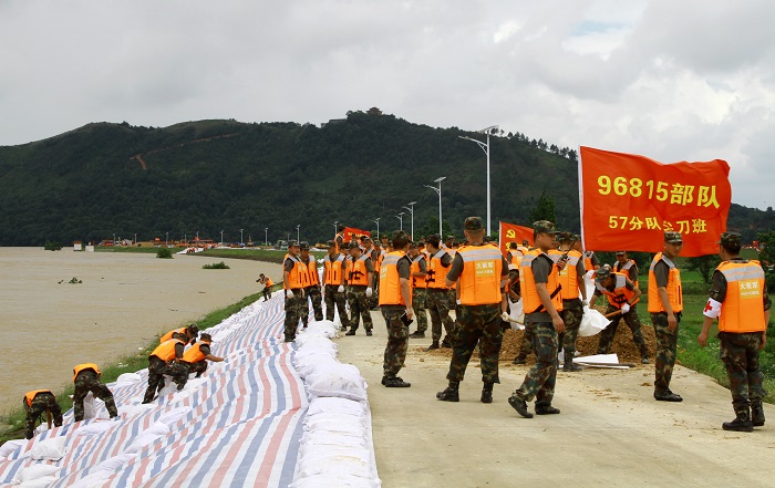 6月21日，火箭军某部官兵在乐北联圩乐港段铺设防浪布，加固堤坝。（程万海 摄）