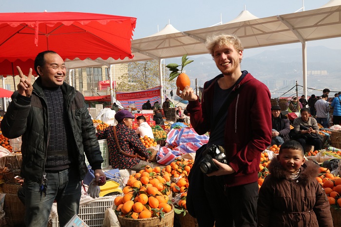 图30：中国恋橙巫山甜柚汁丰味甜，营养丰富，深受游客市民青睐。图为外国游客爱甜柑。唐探峰摄