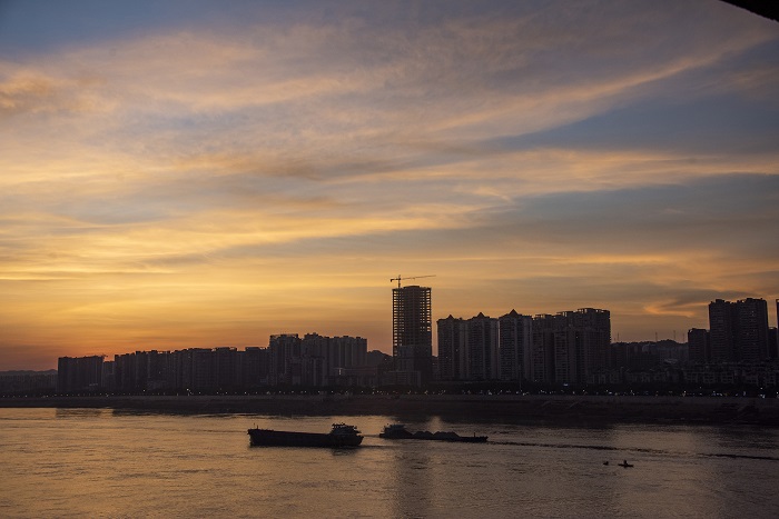 1、2022年7月14日，广西梧州市城市建筑、西江过往船只在晚霞映照下如诗如画，美不胜收。（何华文）