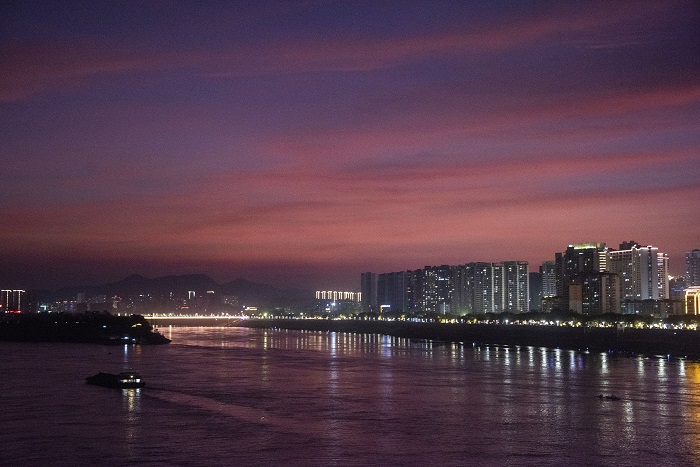 13、2022年7月14日，广西梧州市城市建筑、西江过往船只在晚霞映照下如诗如画，美不胜收。（何华文）