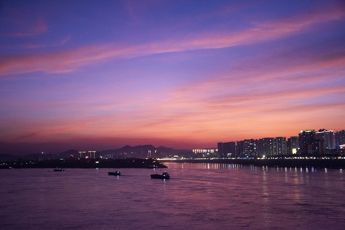 16、2022年7月14日，广西梧州市城市建筑、西江过往船只在晚霞映照下如诗如画，美不胜收。（何华文）