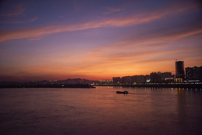 20、2022年7月14日，广西梧州市城市建筑、西江过往船只在晚霞映照下如诗如画，美不胜收。（何华文）