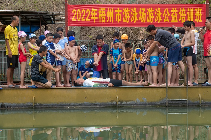 1、2022年7月17日，广西梧州市（桂江一桥边）游泳场内，教练正在对孩子们进行防溺水安全知识教育。（何华文）
