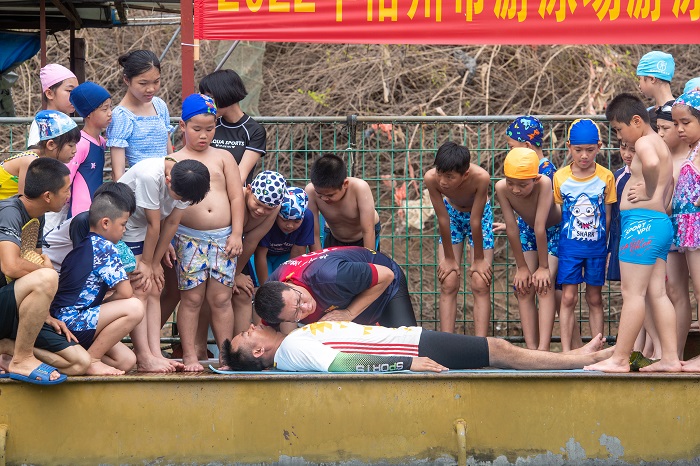 2、2022年7月17日，广西梧州市（桂江一桥边）游泳场内，教练正在对孩子们进行防溺水安全知识教育。（何华文）