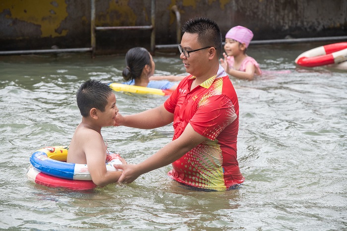 7、2022年7月17日，广西梧州市（桂江一桥边）游泳场内，孩子们在教练的指导下学习游泳技能。（何华文）