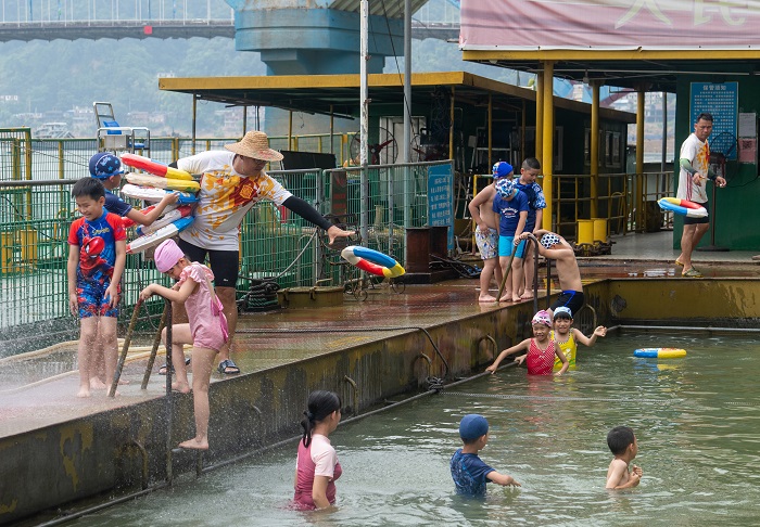 4、2022年7月17日，广西梧州市（桂江一桥边）游泳场内，孩子们在教练的指导下学习游泳技能。（何华文）