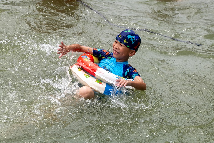 22、2022年7月17日，广西梧州市（桂江一桥边）游泳场内，孩子们在教练的指导下学习游泳技能。（何华文）