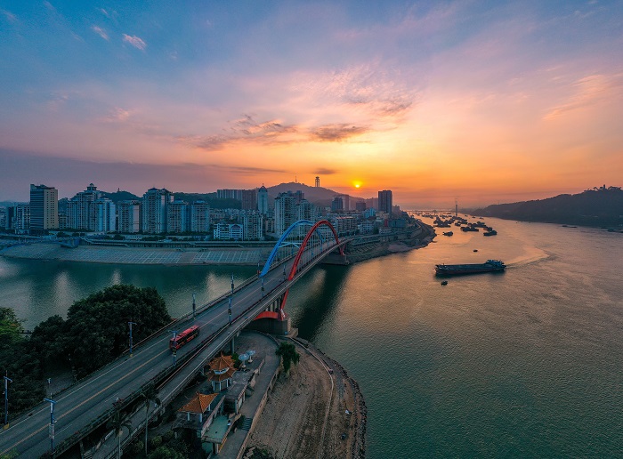 1、2022年8月2日，广西梧州市鸳鸯江上迎来了美丽的朝霞，与城市建筑、江河、过往船只交相辉映，如一幅夏日油画，美不胜收。（何华文）